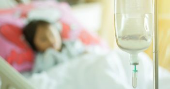fluid debate saline solution and child patient asleep on bed at hospital