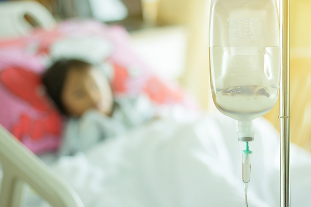 fluid debate saline solution and child patient asleep on bed at hospital