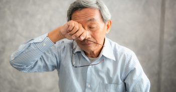 EPM CLL Senior man is holding eyeglasses and rubbing his tired eyes while reading e-book in tablet